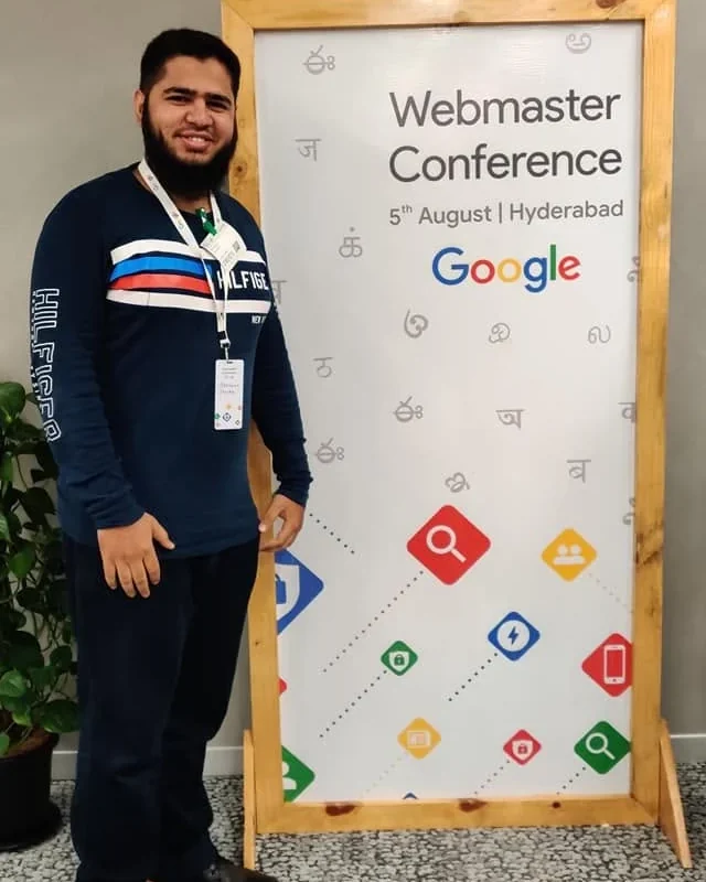 Shaikh Simraan at the Google Webmaster Conference in Hyderabad, standing beside the event signage
